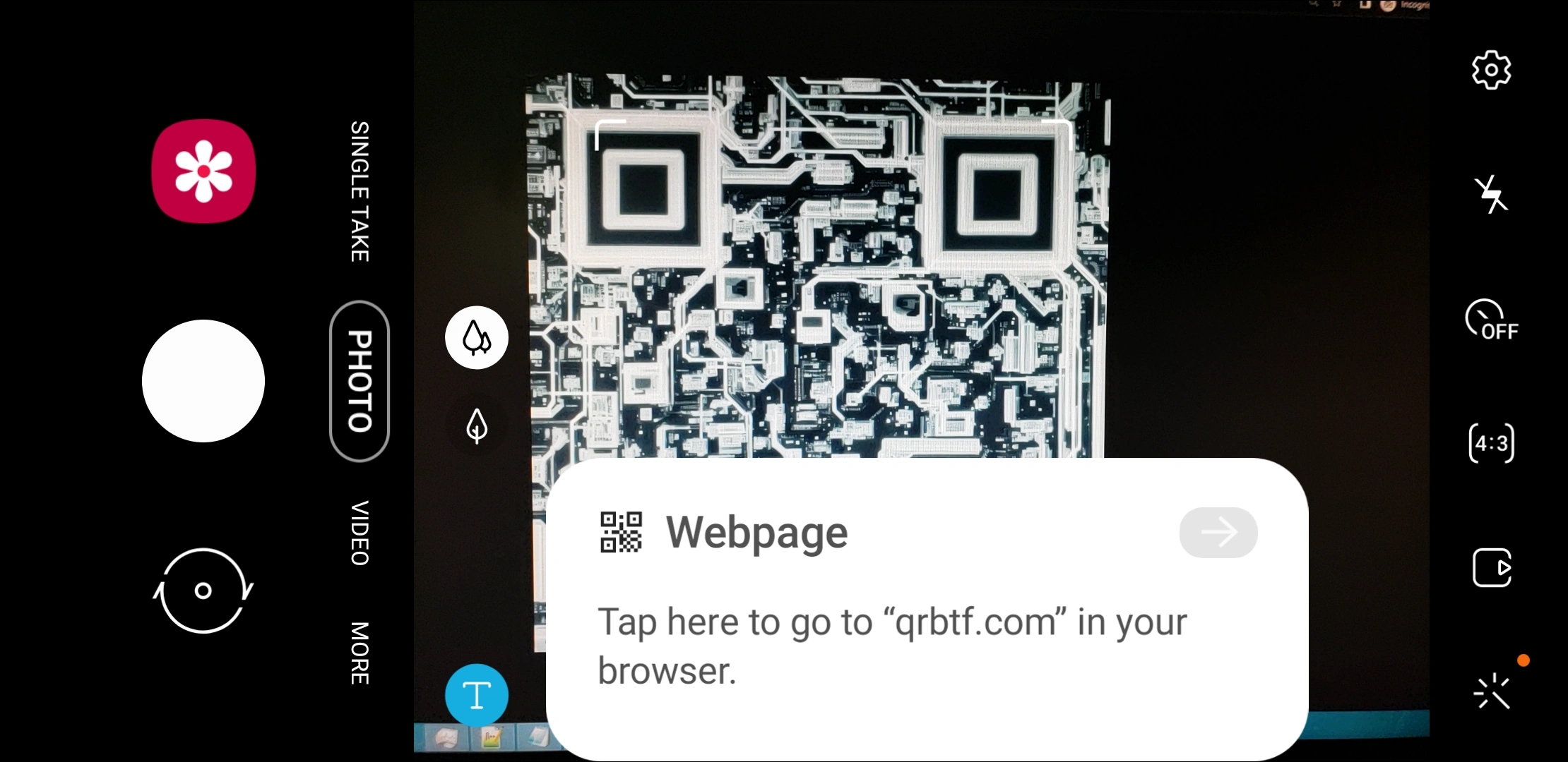 A screenshot of using the camera app on my phone, with the camera pointed at my computer monitor. The monitor shows an overhead view of a cityscape. The camera app detects the various buildings as a valid QR code.